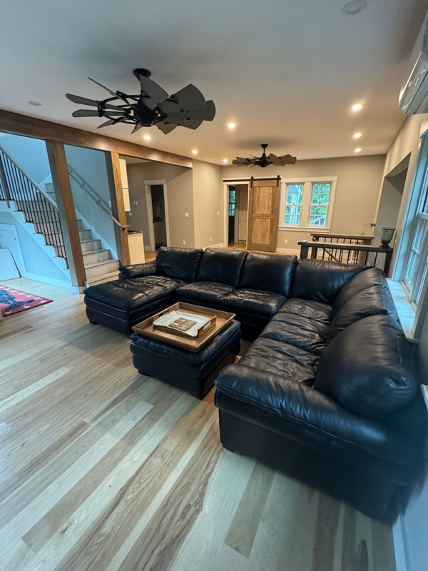 Living room with black leather sectional sofa.