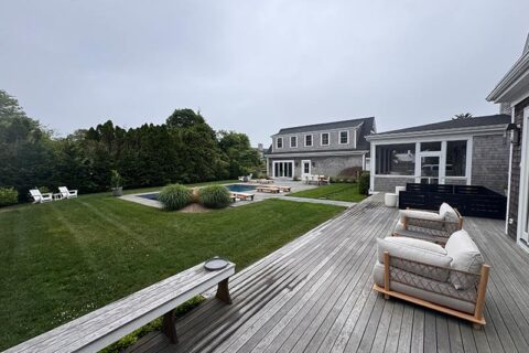 An outdoor deck with a pool and various lawn furniture